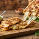 Com diferentes versões de Rap10, escolhas fáceis e aconchegantes mostram como é possível criar pratos deliciosos em poucos minutos Quando a temperatura cai e a rotina pede praticidade, as receitas rápidas ganham espaço à mesa. Pensando nisso, Rap10, da Bimbo Brasil, surge como um aliado versátil para transformar o jantar do dia a dia em uma experiência saborosa, criativa e descomplicada. Com massas prontas para uso e diferentes versões no portfólio, a marca permite combinações que vão do clássico ao sofisticado, sempre com rapidez no preparo. Um exemplo é a quesadilla de frango com queijo derretido, preparada com Rap10 Original, para quem busca um jantar mais indulgente e cheio de conforto. A receita começa com peito de frango desfiado refogado na frigideira com cebola roxa levemente caramelizada no azeite, ganhando ainda mais sabor com o toque de sal e pimenta-do-reino. Sobre a massa, o requeijão cremoso cria uma camada aveludada que ajuda a envolver o recheio e intensifica a cremosidade do prato. Finalizada com bastante queijo muçarela, a quesadilla é tostada até ficar dourada por fora e macia por dentro. Ao ser cortada em triângulos, revela o queijo derretido se misturando ao frango quente, um prato perfeito para noites frias e refeições compartilhadas. Já para quem prefere sabores mais sofisticados e equilibrados, a aposta é o wrap de forno com queijo brie, mel e nozes, agora preparado com Rap10 Fibras. A combinação une praticidade e sabor a um benefício importante para o dia a dia: a maior sensação de saciedade proporcionada pelas fibras presentes na massa. O sabor suave do Rap10 Fibras harmoniza perfeitamente com a intensidade amanteigada do queijo brie, que derrete delicadamente no forno em poucos minutos. As nozes picadas acrescentam crocância e profundidade ao sabor, enquanto o mel traz um contraste adocicado que transforma a receita em uma experiência elegante e acolhedora. Para finalizar, folhas frescas de tomilho adicionam aroma e frescor ao prato, que pode ser servido tanto como um jantar leve quanto como entrada para receber convidados em casa. Para os fãs de soluções mais leves e criativas, a sugestão é uma pizza crocante de abobrinha e tomate cereja, utilizando Rap10 Fit como base. O molho de tomate espalhado sobre a massa cria a estrutura perfeita para os vegetais frescos: rodelas finas de abobrinha e tomates cereja assados até ficarem levemente tostados e suculentos. O queijo branco esfarelado adiciona suavidade e equilíbrio à receita, enquanto o orégano intensifica o aroma típico das pizzas artesanais. Depois de alguns minutos no forno ou na airfryer, a massa ganha uma textura extremamente crocante, contrastando com o recheio suave e fresco. Finalizada com um fio de azeite extravirgem, a receita é ideal para quem quer praticidade sem abrir mão de sabor. “Hoje, contamos com um portfólio que equilibra conforto, leveza e sofisticação, valorizando a versatilidade na cozinha e mostrando que receitas práticas e rápidas também têm o poder de transformar ocasiões simples em momentos especiais à mesa”, afirma Gustavo Rosa, diretor de marketing de snacks salgados, doces e tortilhas da Bimbo Brasil.